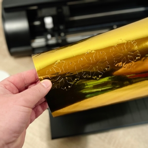 Im Plotter von Silhouette America wurden testweise Schneeflocken aus goldener Folie ausgeschnitten.