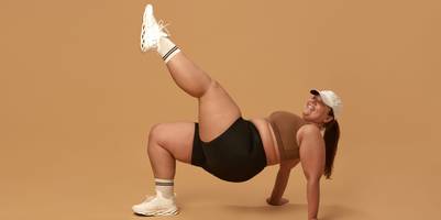 lachende-frau-mit-übergewicht-macht-sportübung