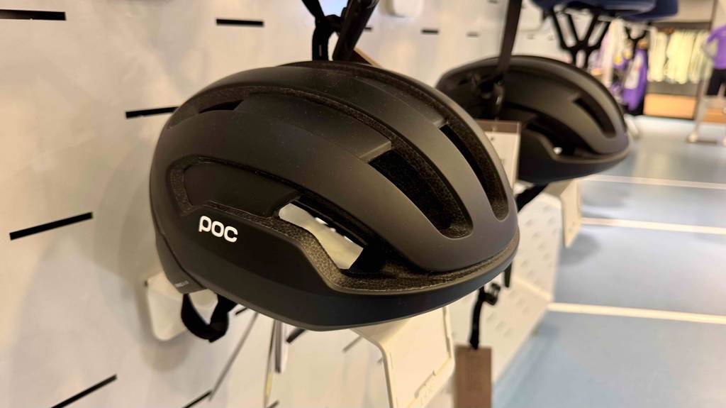 Ein poc-Fahrradhelm hängt zum testen an einem Regal.