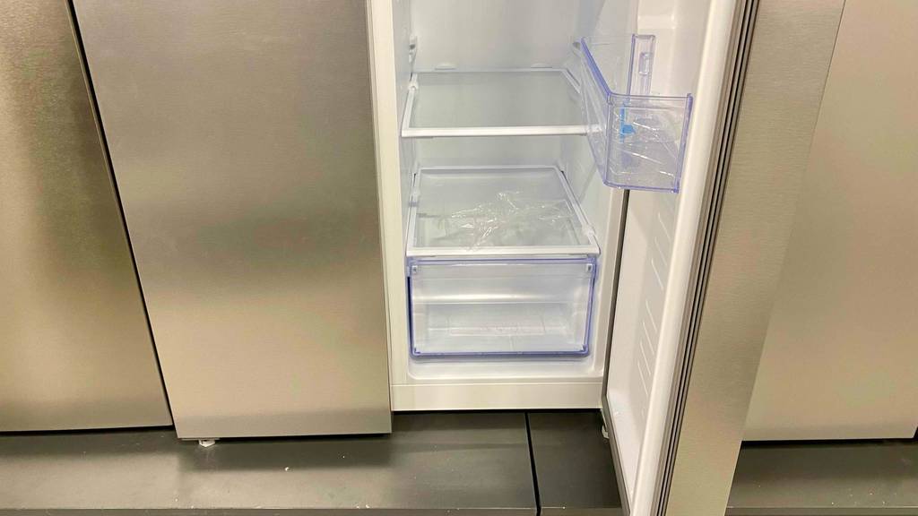 Side-by-Side-Kühlschrank im Test: Detailaufnahme des unteren Bereichs mit geöffneter Tür, mit Fokus auf die transparente Schublade und die Glas-Einlegeböden.