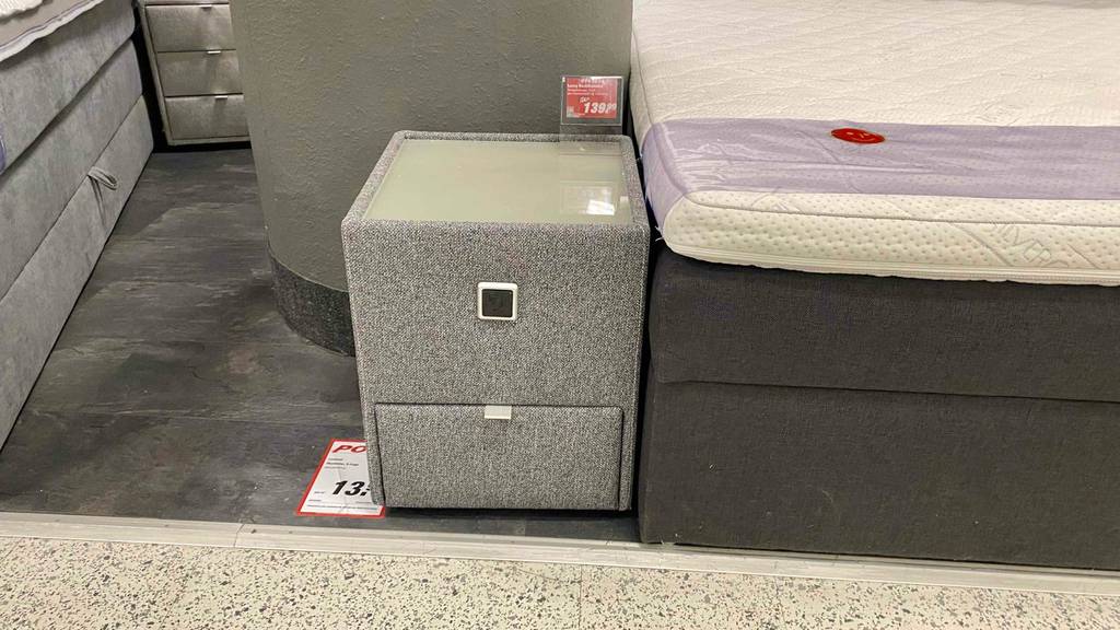 Im Test: Ein Nachttisch für das Boxspringbett in Frontansicht steht neben einem Bett.