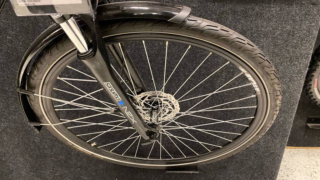 Trekking-E-Bike Herren: Vorderrad eines schwarzen E-Trekkingbikes für Herren im Test.