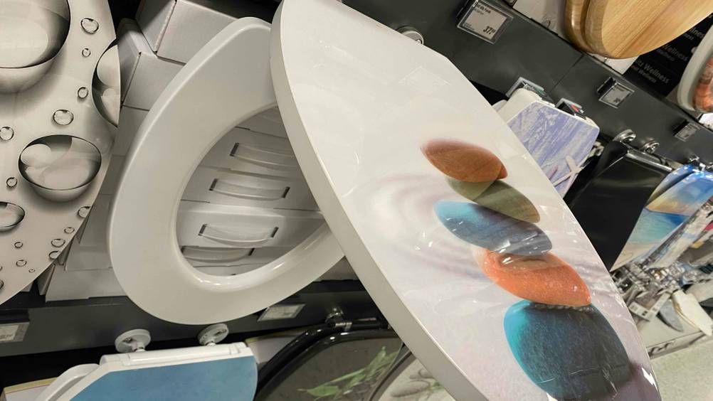 Detailansicht des Deckels eines getesteten WC-Sitz mit buntem Steindesign.
