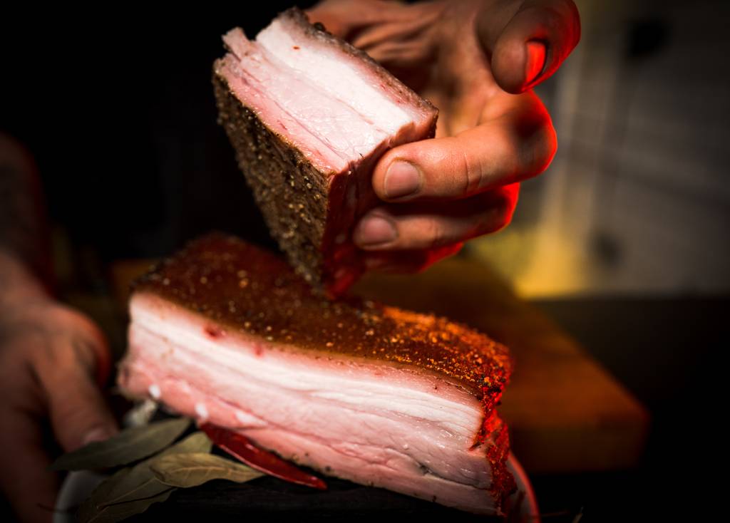 Pökelsalz-Test: Ein Mann hält zwei Stück Fleisch in der Hand. 