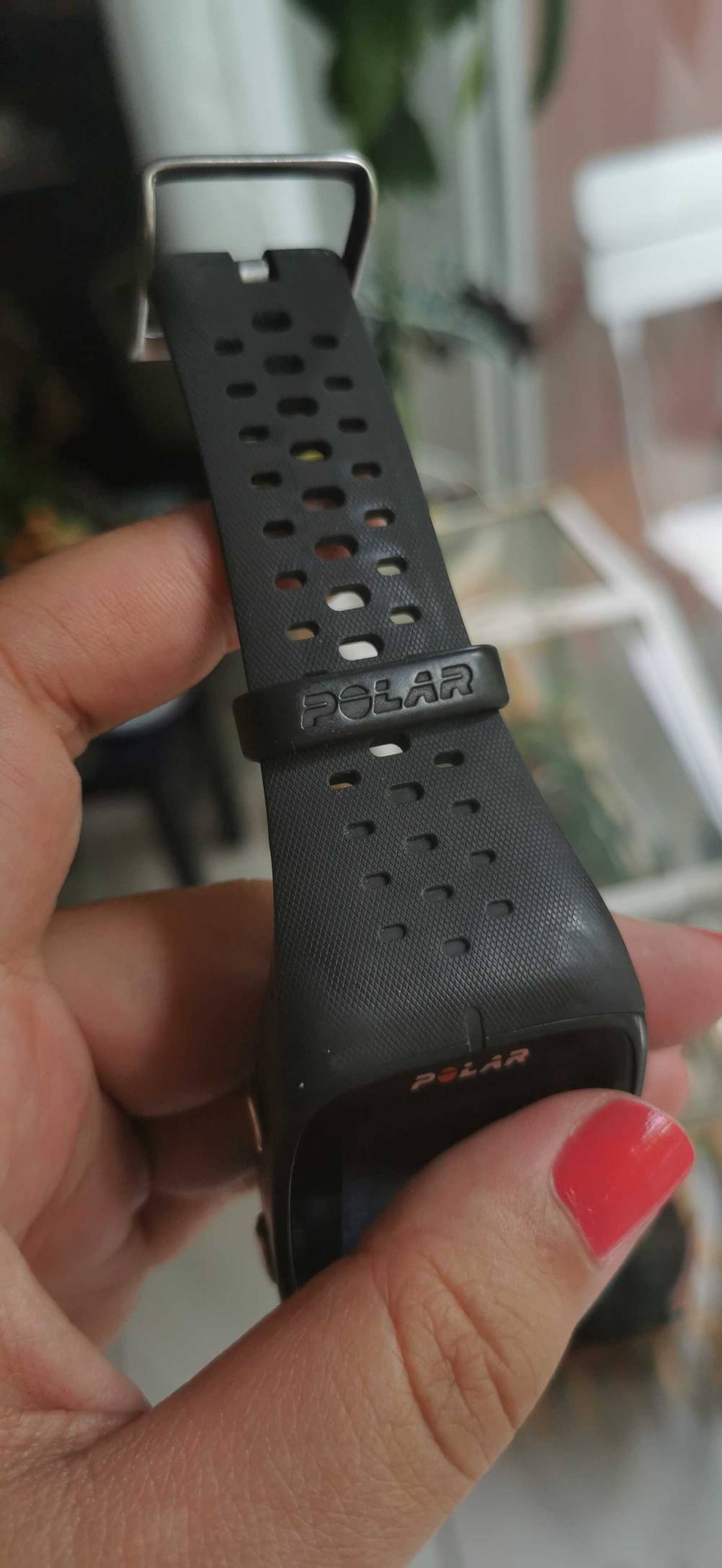 Polar-Fitnessuhr getestet: Nahaufnahme des Bandes mit Logo von einer Hand gehalten.