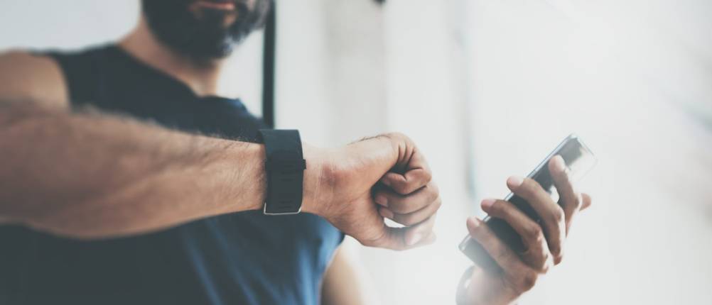 Polar-Fitnessuhr-Test: Mann schaut auf seine Uhr am Handgelenk.