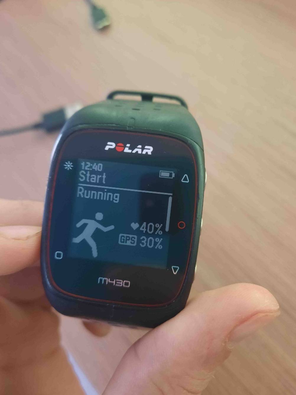 Nahaufnahme des Displays einer Polar-Pulsuhr im Test, von einer Hand gehalten.