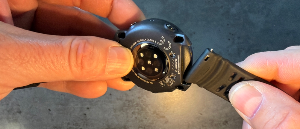 Eine Hand befestigt das Armband an der Polar Vantage M3