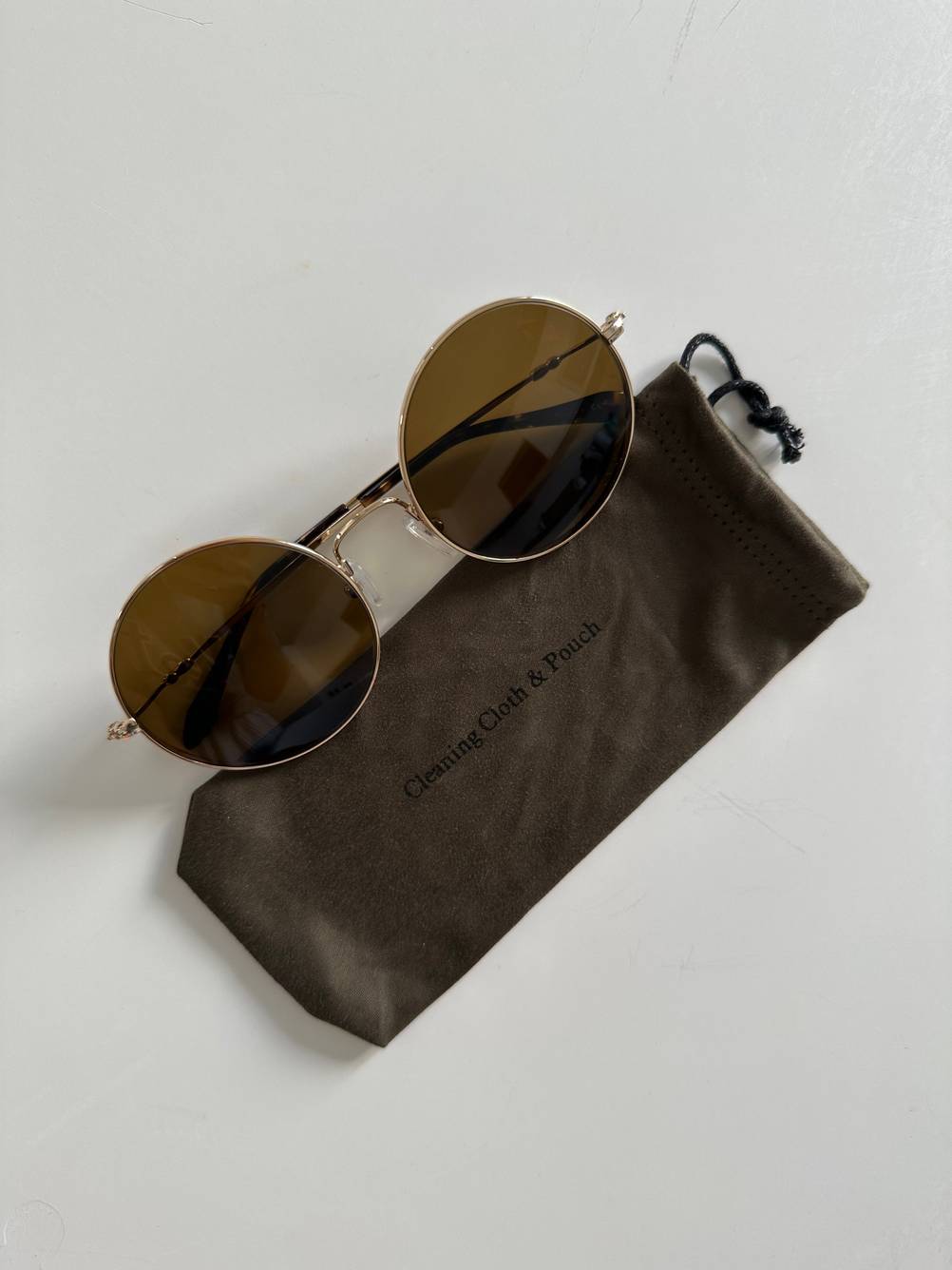 Auf einer hellen Fläche liegt die getestete polarisierte Sonnenbrille leicht über ihrem Case.