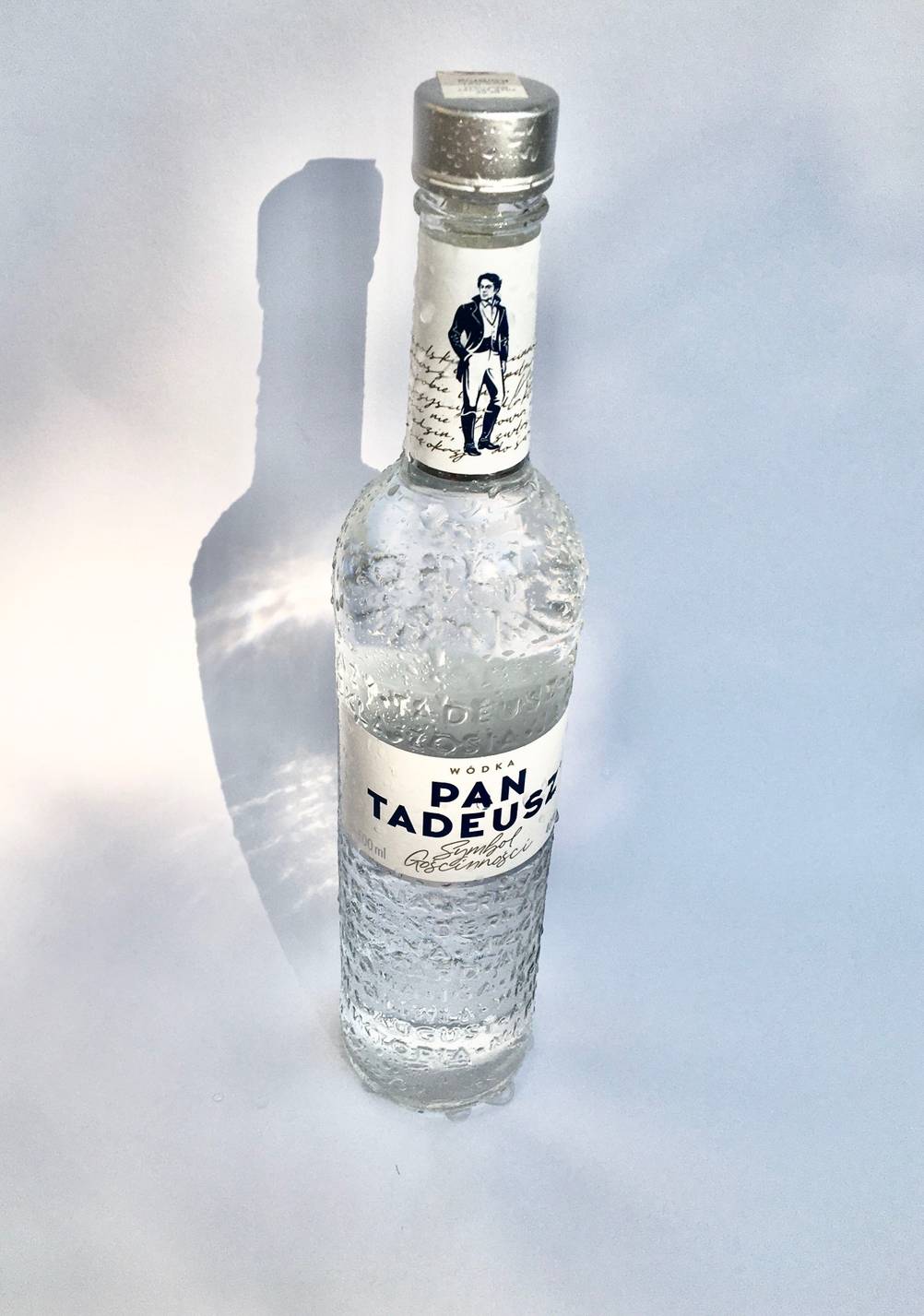Getesteter polnischer Wodka befindet sich in einer Glasflasche auf einer weißen Oberfläche.
