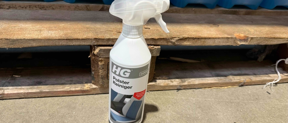 Eine Flasche Polsterreiniger im Test steht vor einer Holzpalette.