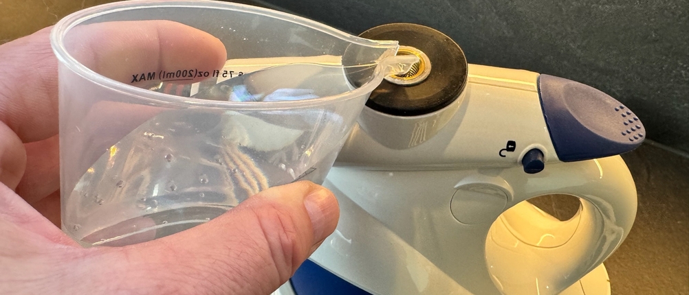 Eine Hand schüttet Wasser in den POLTI FIRST PGEU0011