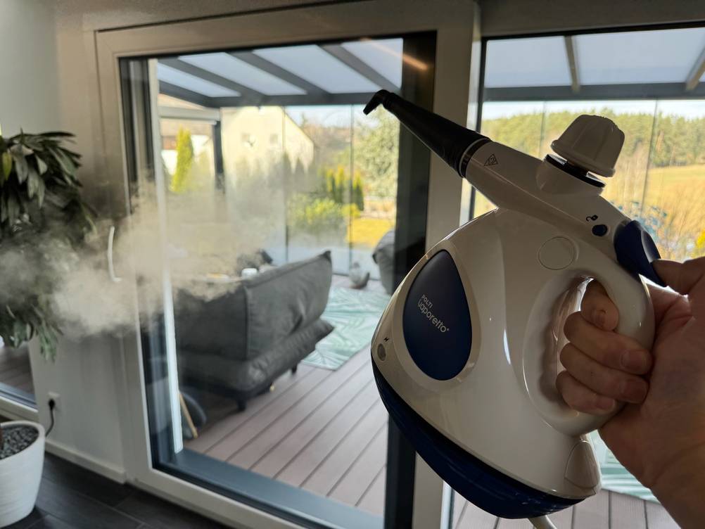 Der POLTI FIRST PGEU0011 wird von einer Hand gehalten und dampft in die Luft