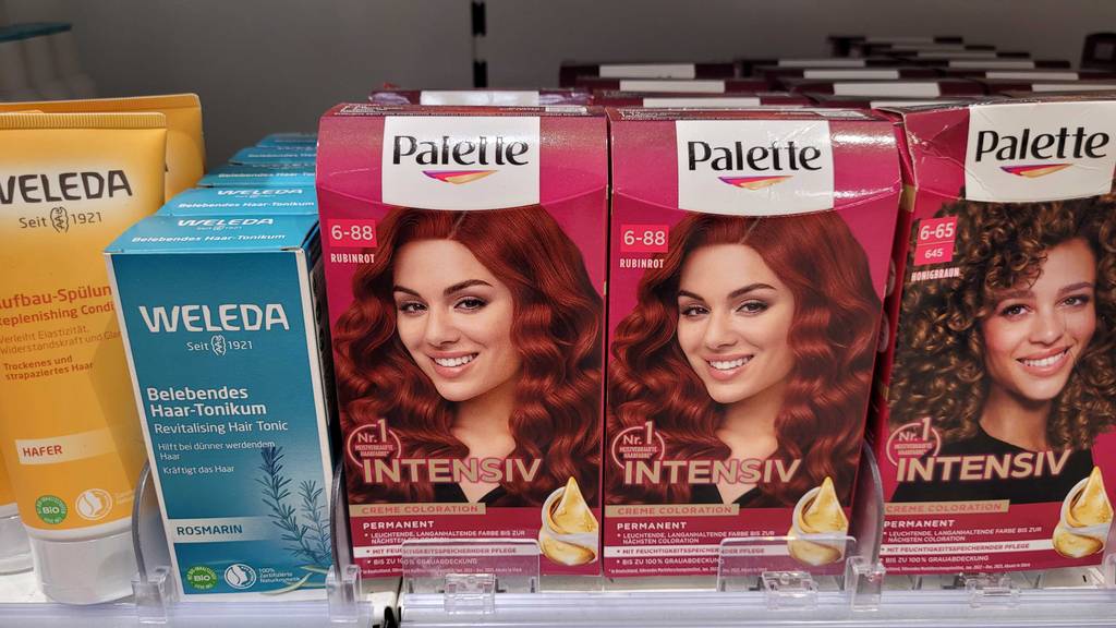 Getestet: rote Haarfarbe in einer Verpackung mit intensiver Creme-Koloration neben anderen Haarpflegemitteln.