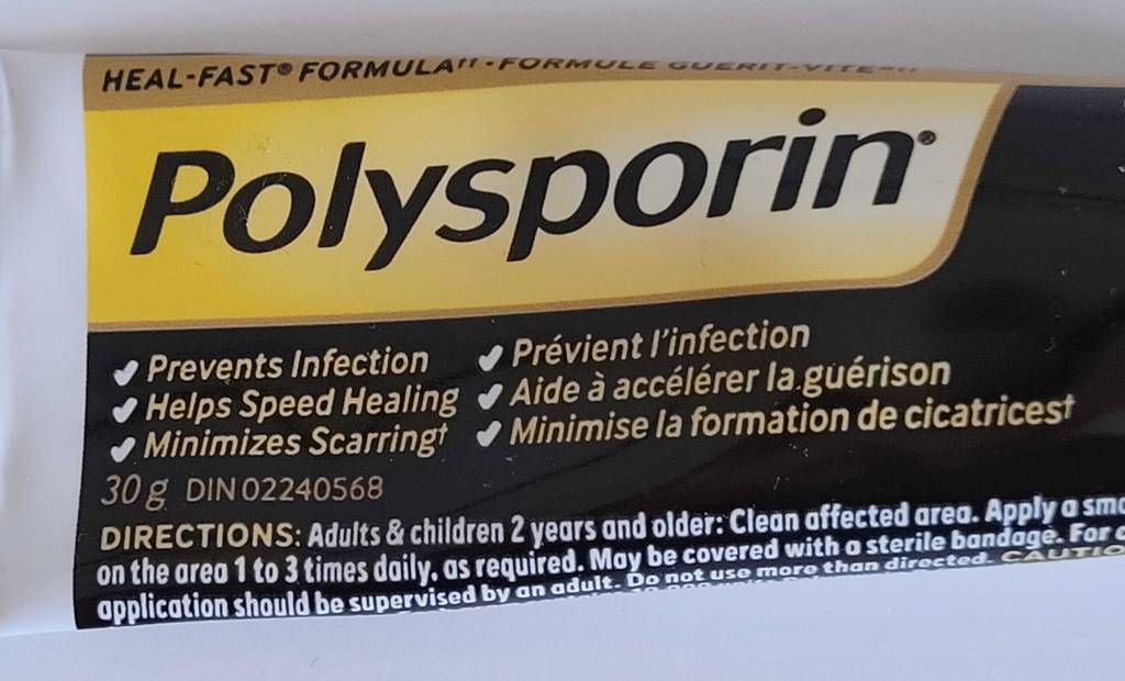 Nahaufnahme der Produktbeschreibung auf einer schwarz-weiß-gelben Tube mit Polysporin Narbengel im Test.