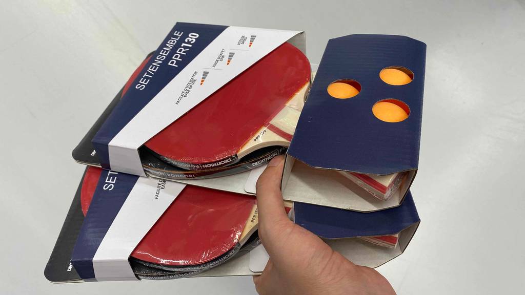 Im Test: Hand hält zwei verpackte Tischtennisschläger Sets.