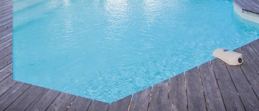 Pool-Alarm im Praxis-Test: In einem eckigen Pool mit Holzumrandung befindet sich am Beckenrand ein Pool-Alarm.
