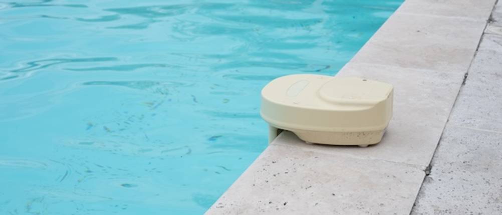 Pool-Alarm zuhause getestet: Ein beigefarbener Pool-Alarm ist auf dem Beckenrand eines Swimming-Pools aufgestellt.