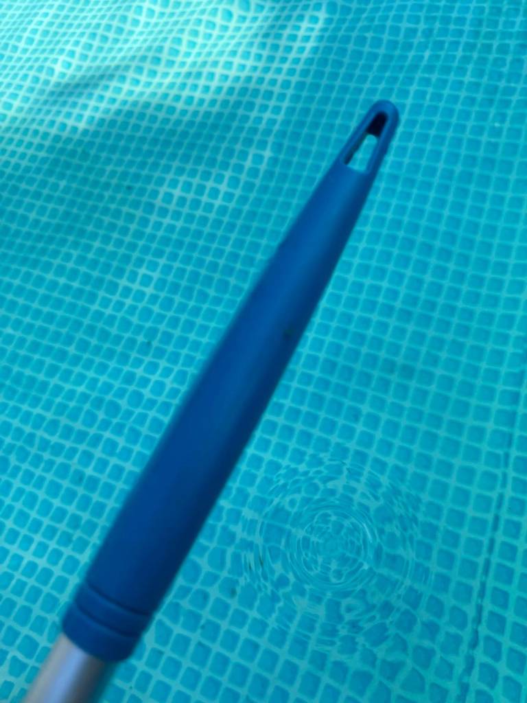 Pool-Kescher-Test: Detailansicht des rutschfesten Griffs eines Pool-Keschers vor einer Wasseroberfläche.