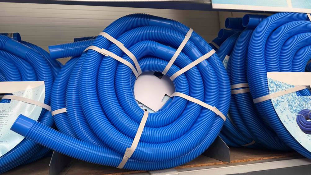 Mehrere verpackte Poolschläuche im Test in einem Verkaufsregal.