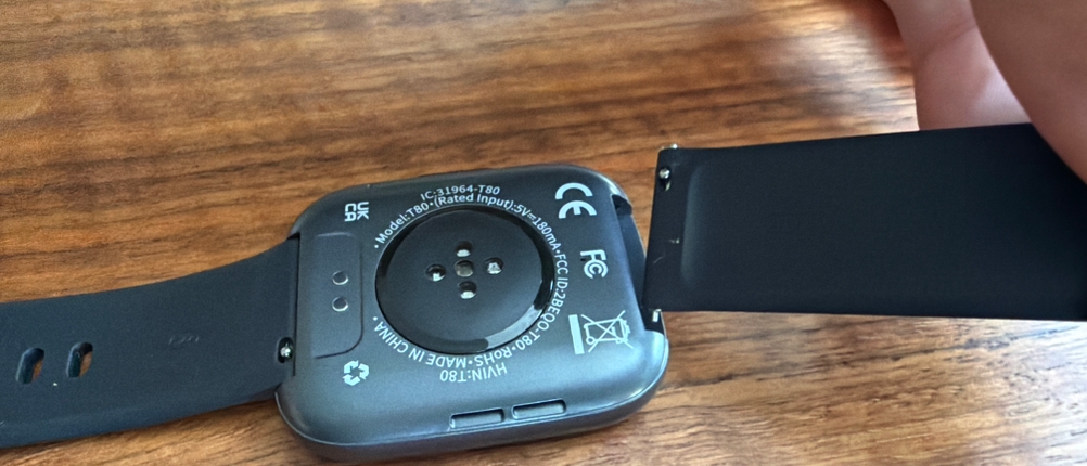 Eine Hand entfernt einen Teil vom Armband der Poounur-T80-Smartwatch