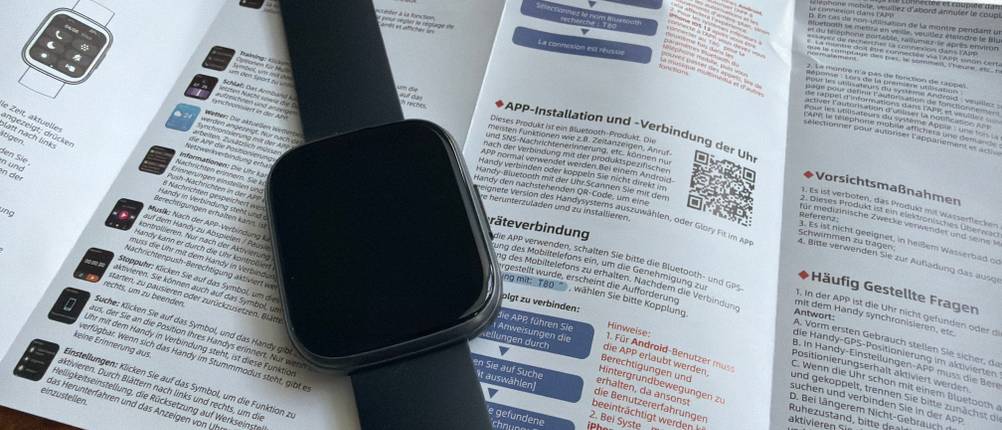 Die Poounur-T80-Smartwatch liegt auf der Anleitung