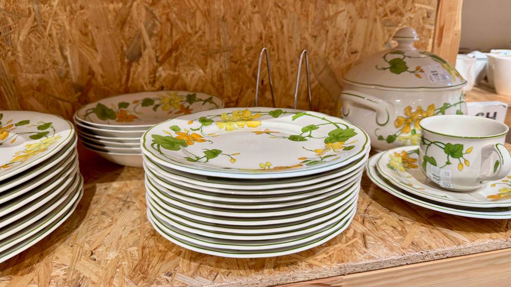 Porzellan-Teller im Test: Mehrere Teller übereinander neben anderen Produkten in einem Regal.
