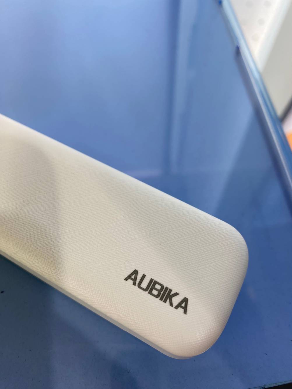 Nahaufnahme des Logos auf einer getesteten Powerbank auf blauem Untergrund.