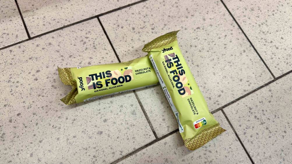 Powerbar Riegel getestet: Zwei Riegel leicht übereinander auf dem Boden liegend.