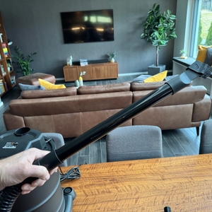 Eine Hand hält eine Verlängerung des Schlauchs des Powerplus pow X308 in der Hand