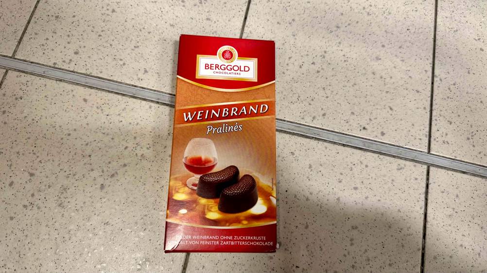 Eine Packung der getesteten Pralinen mit Alkohol auf einem Fließenboden.