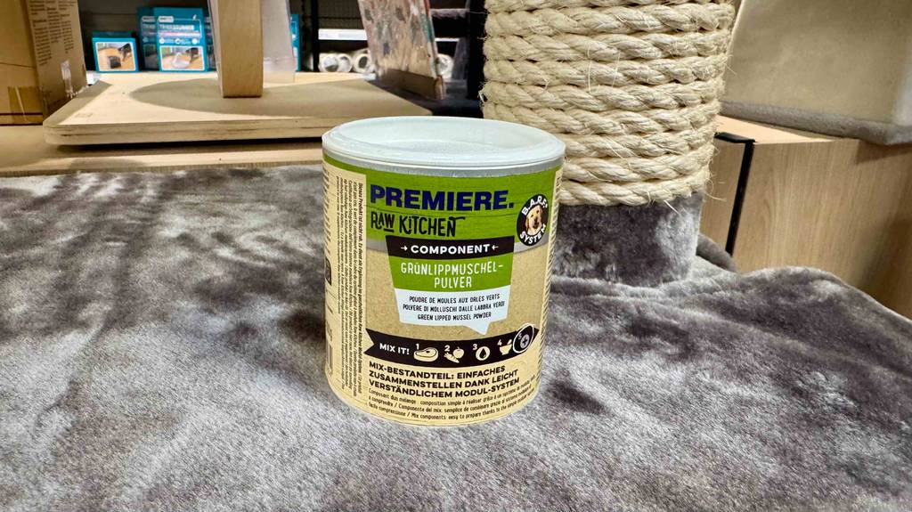 Im Test: Das Grünlippmuschelpulver in der Dose steht auf einer grauen Hundedecke im Geschäft für Tierprodukte.