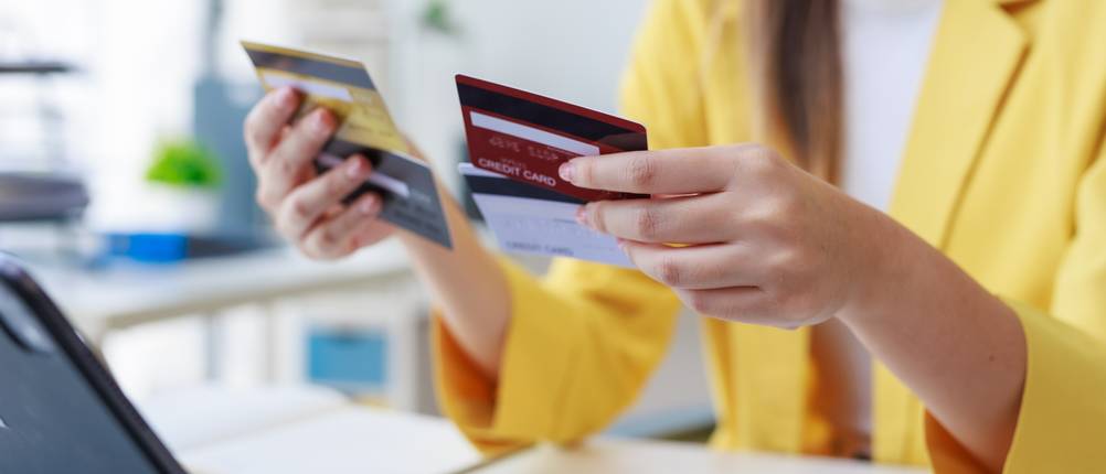 Ein Frau hält mehrere aufladbare Kreditkarten in der Hand.