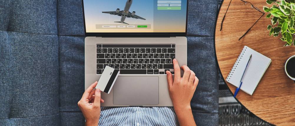 Eine Frau bucht mit einer aufladbaren Kreditkarte eine Reise.