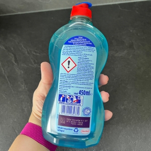 Eine Hand hält die Flasche des Pril-5+-Kraft-Gels Antibakteriell mit der Rückseite nach oben.