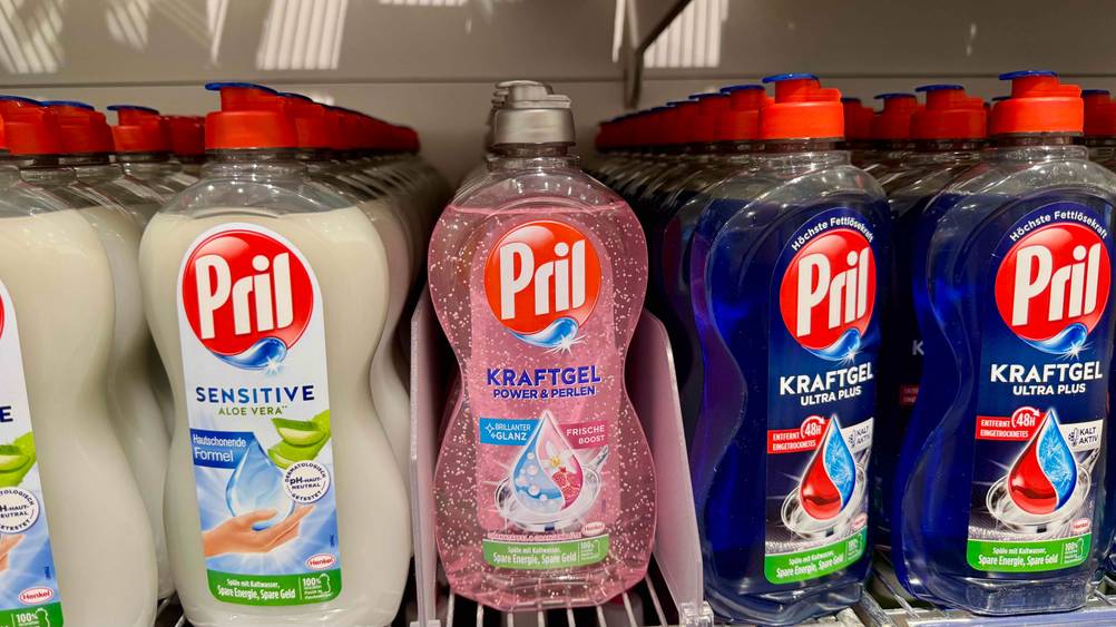 In einem Regal stehen mehrere Flaschen des getesteten Pril-Spülmittels neben anderen Produkten.