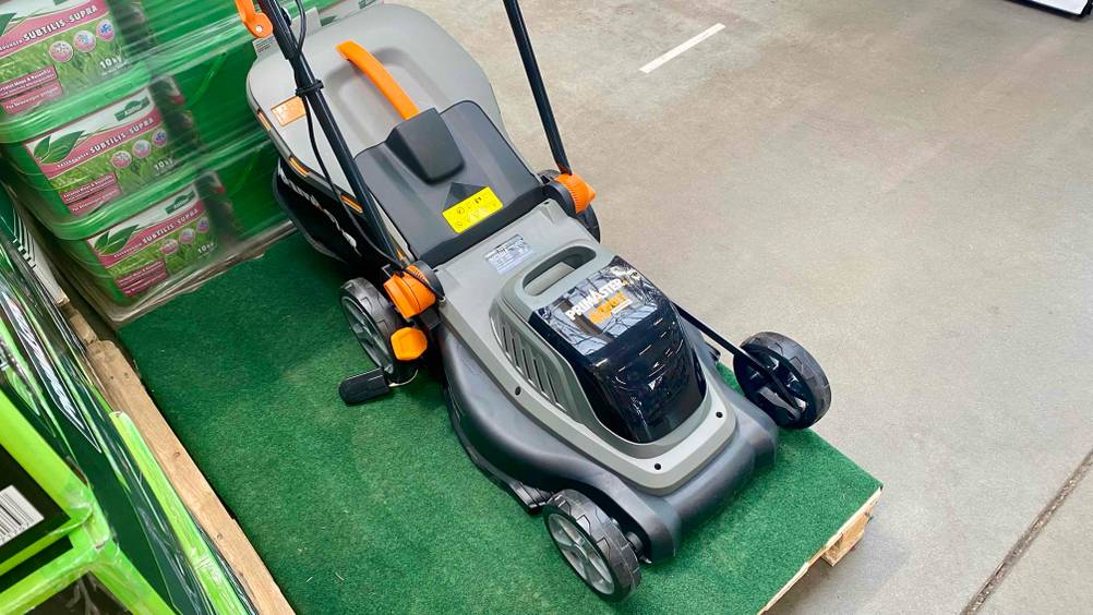 Im Test: Ein Akku-Rasenmäher mit Mulchfunktion von Primaster von schräg oben auf einem Kunstrasen stehend.