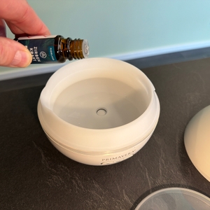 Eine Hand gibt Zirbenöl in den Primavera Feel Happy 42008