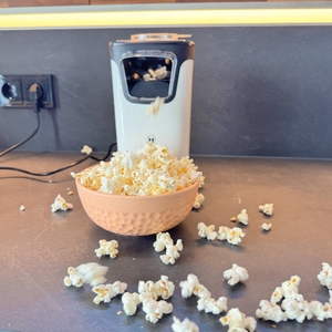 Popcorn kommt aus der Princess 01.292986.01.001 und fällt in eine Schale sowie auf eine Arbeitsplatte