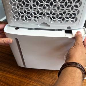 Zwei Hände setzen den Behälter in den Pro Breeze PB-08 ein