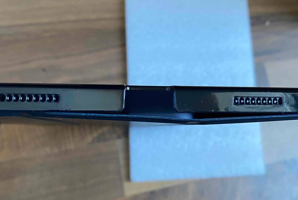 Detailansicht der Audioaussparungen einer getesteten Tablet-Hülle vor Holzhintergrund.