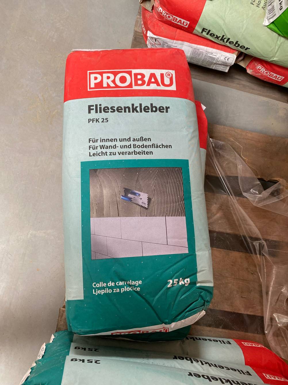 Getestet: Ein Sack Fliesenkleber von Probau, von oben betrachtet, liegt auf einer Palette.