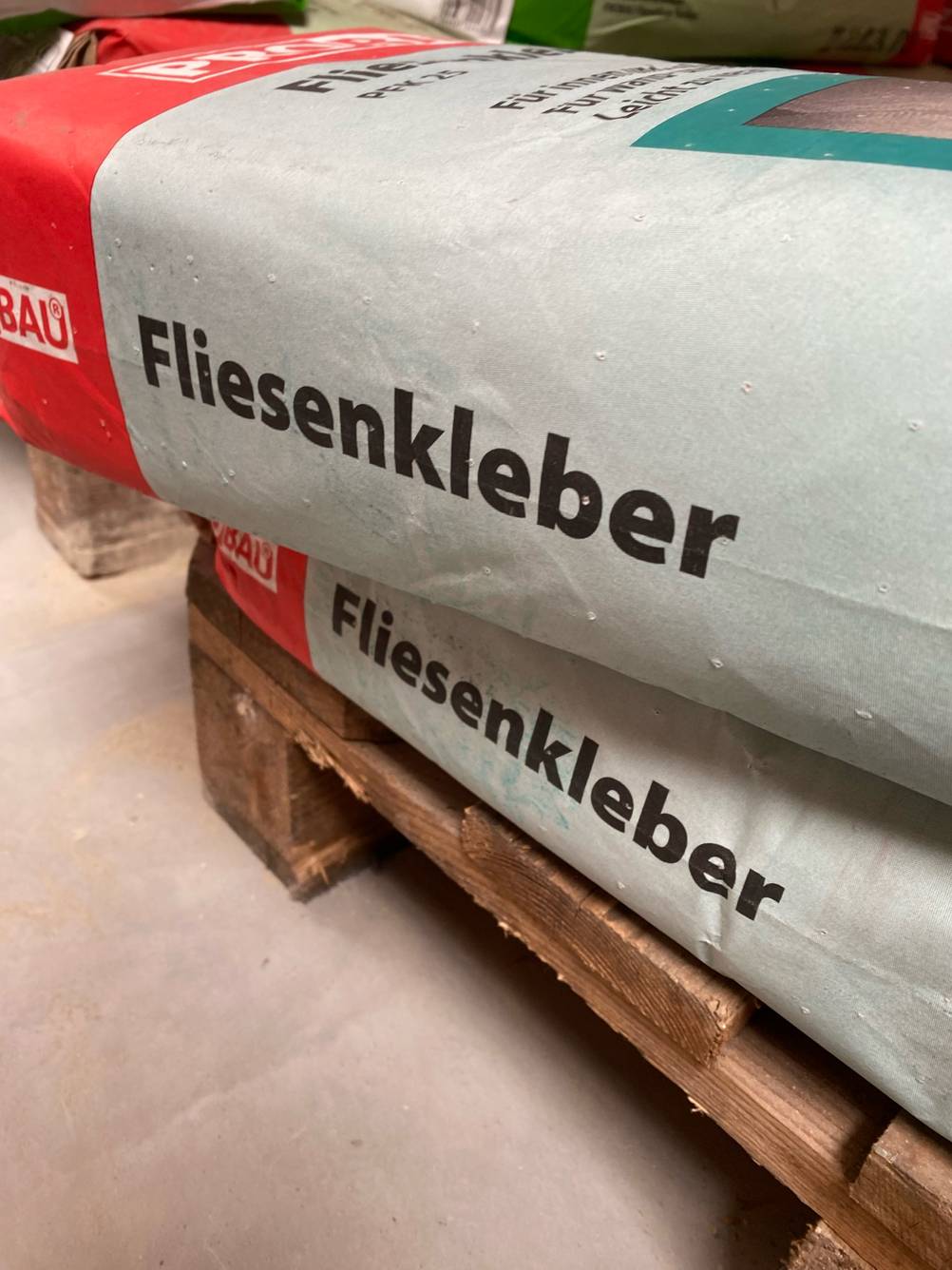 Im Test: Auf zwei großen Säcken auf einer Palette steht in Großschrift Fliesenkleber.