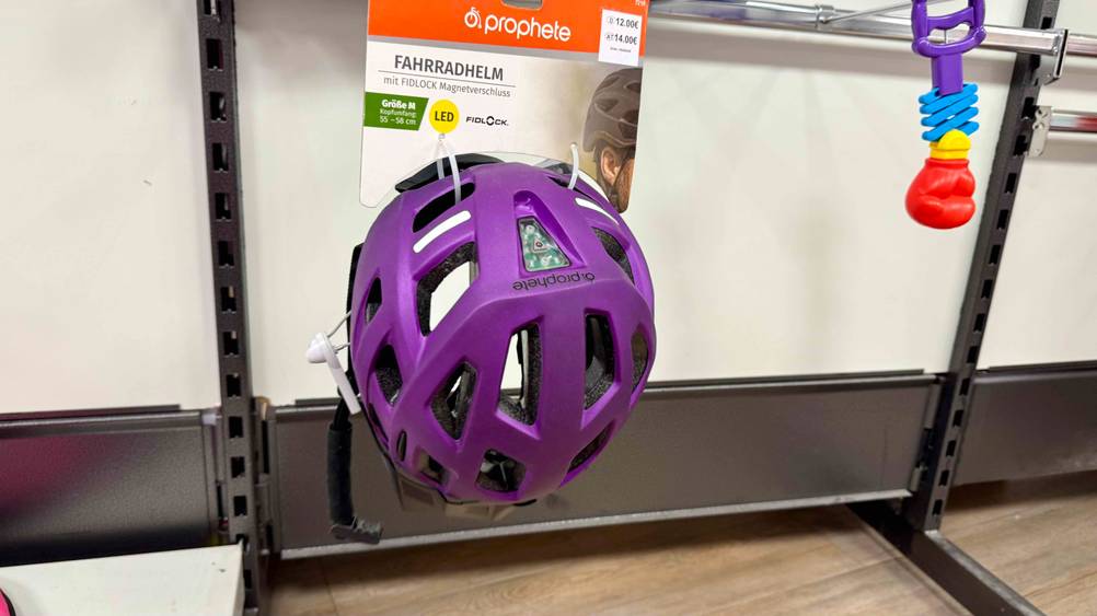 Der getestete Prophete-Fahrradhelm hängt in einem Verkaufsregal. Das Logo ist auf der Rückseite sichtbar.