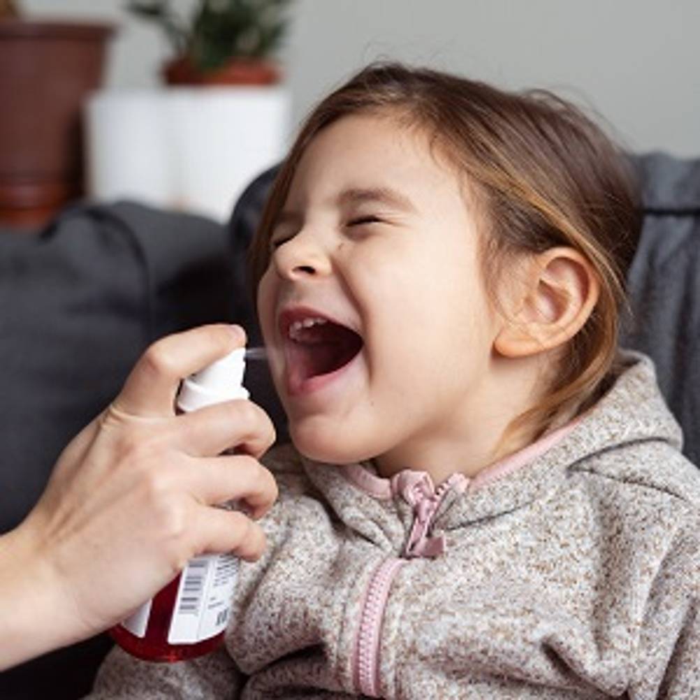 Propolis-Spray im Test: Kind, das mit Propolis-Spray behandelt wird