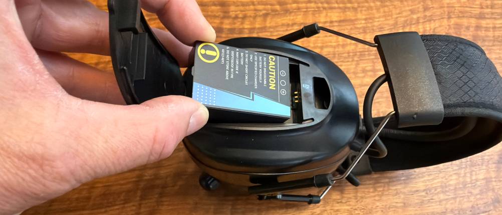 Eine Hand legt einen Akku in den Protear E8830BTDAB+.