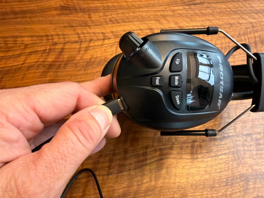 Eine Hand steckt ein Kabel in den Protear E8830BTDAB+.