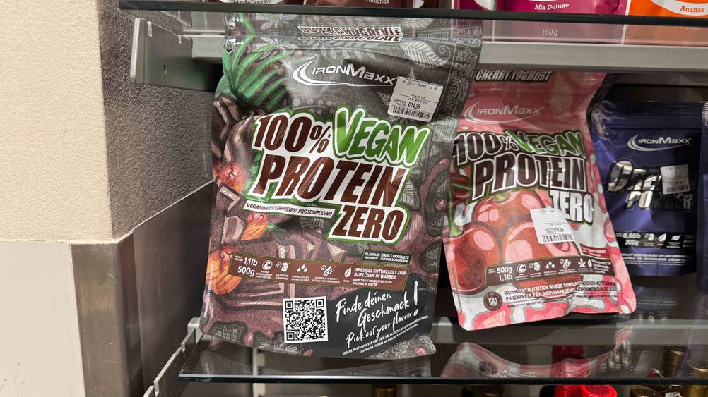 In einem Regal neben anderen Produkten befindet sich das getestete Schoko-Proteinpulver.