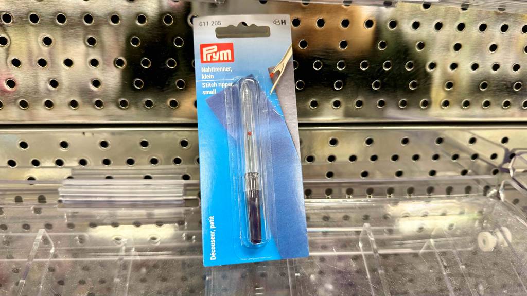Ein getesteter Nahttrenner liegt in Blisterverpackung auf einer Glasfläche.