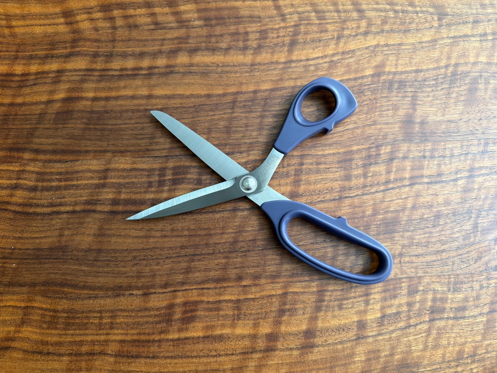 Die Prym-Schneiderschere liegt geöffnet auf einem Tisch